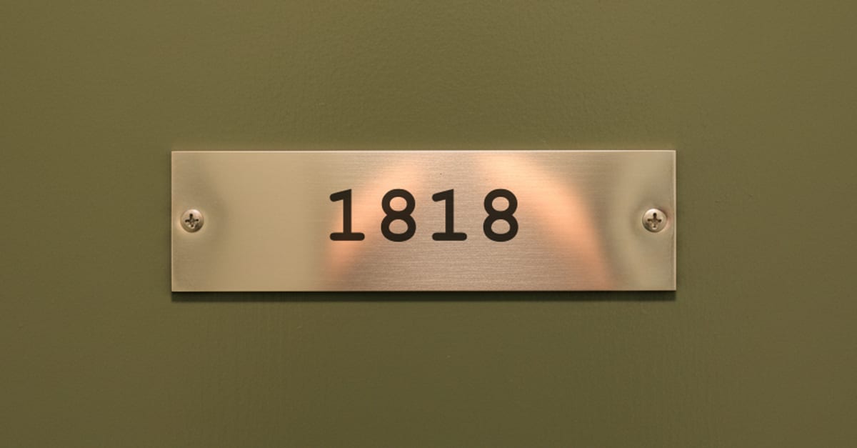 A brushed steel plate on an office door, engraved 1818.